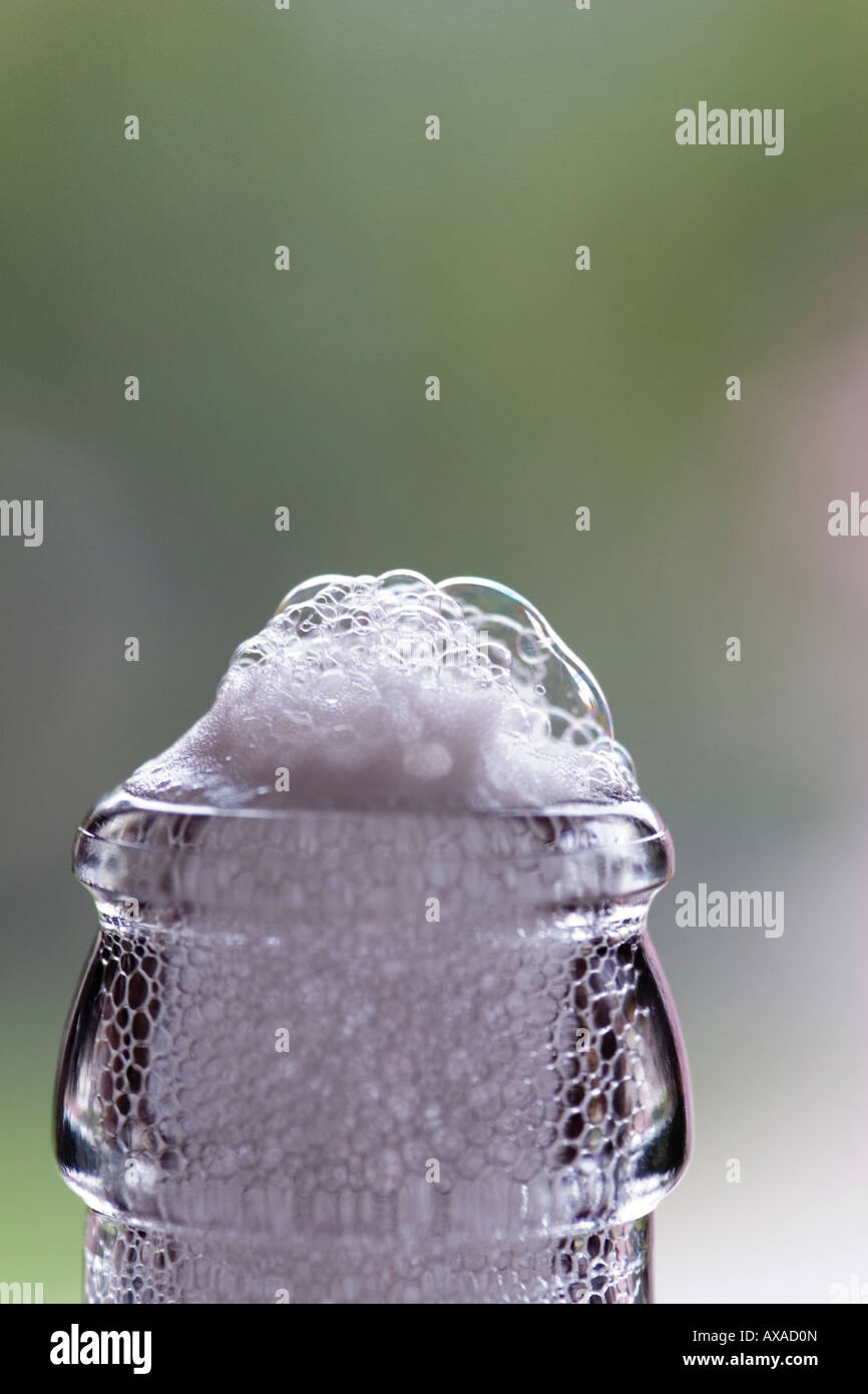Suds overflow a bottle or beer Stock Photo Alamy