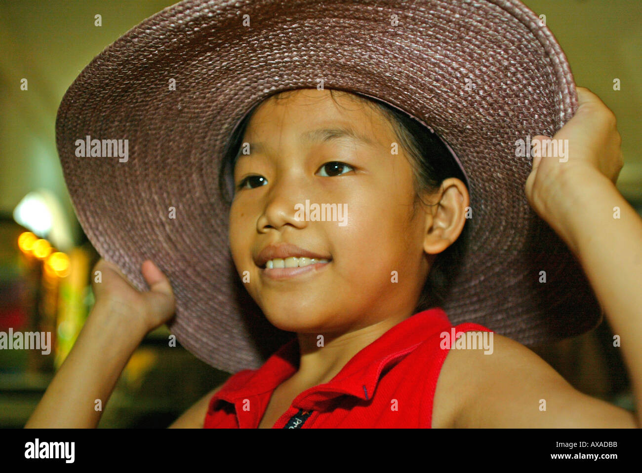 Young girl tries on sun hat Chiang Mai Thailand Stock Photo