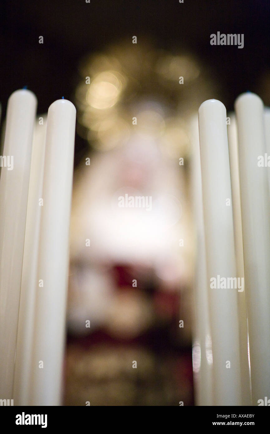 Candles on a Holy Week float with the blurred image of the Virgin on