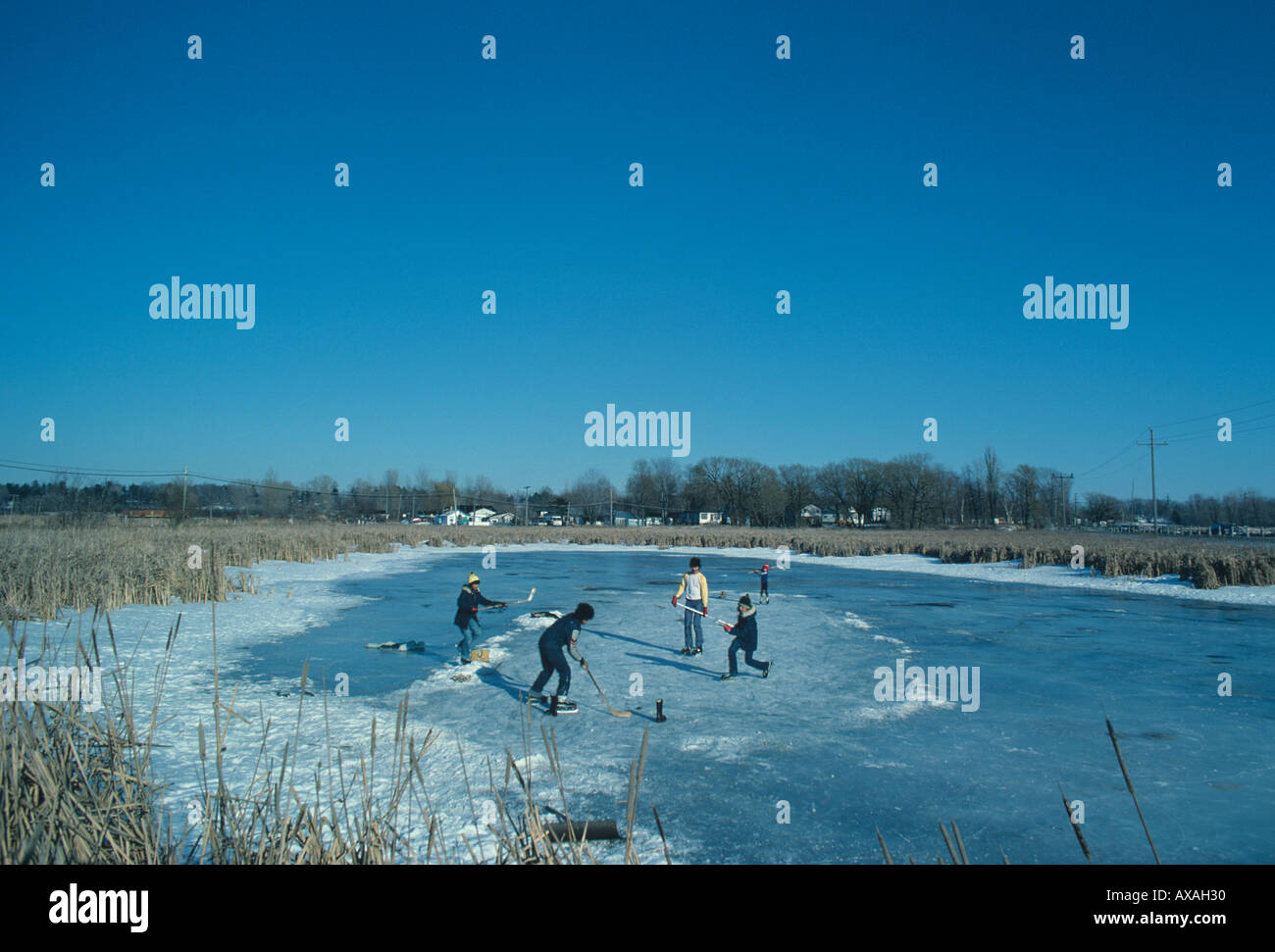 Boys playing hockey on frozen pond most are Vietnamese New Canadians Kingston Ontario Stock Photo
