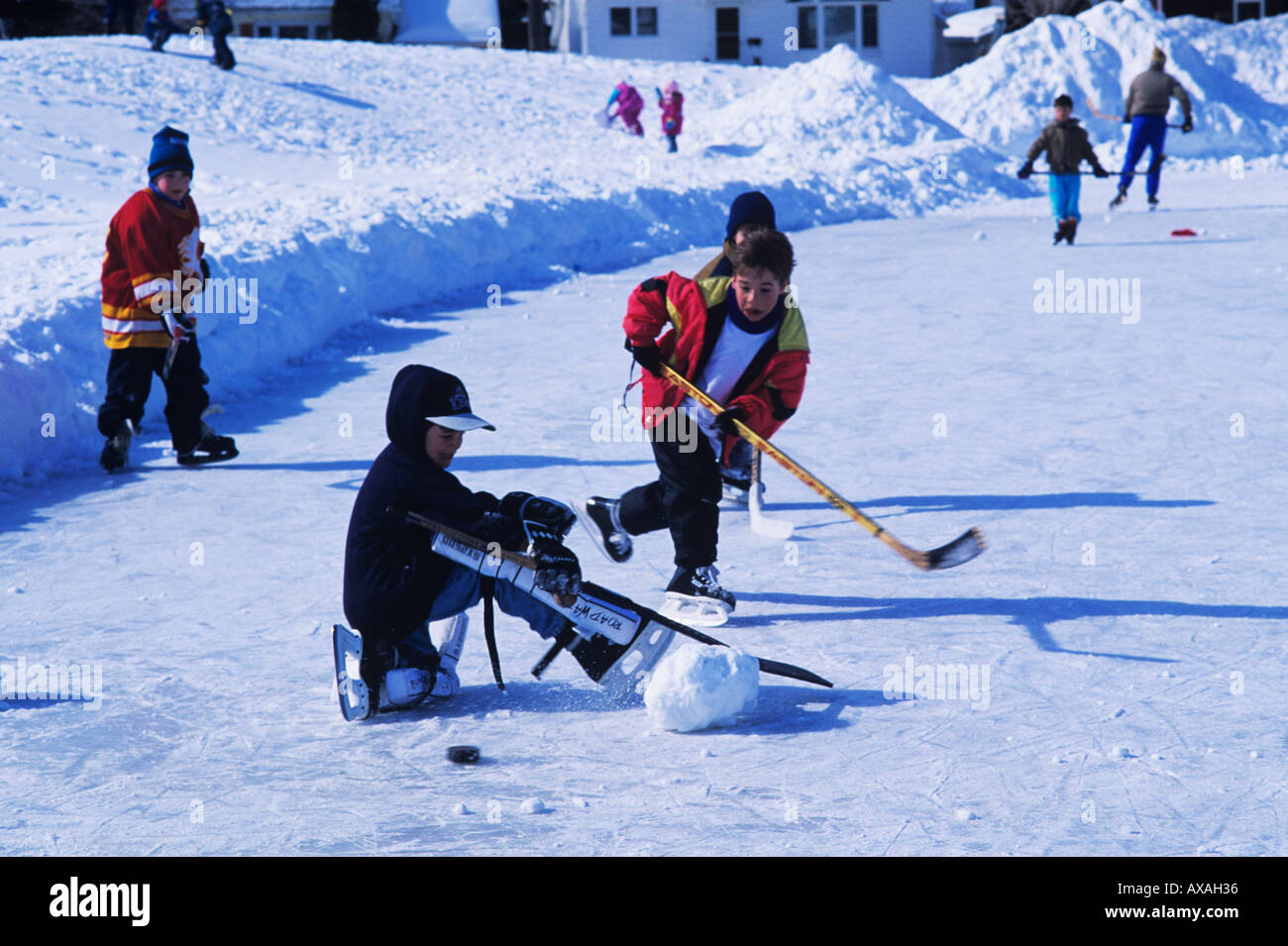 Canadian children playing hockey on public rink in local park Stock Photo