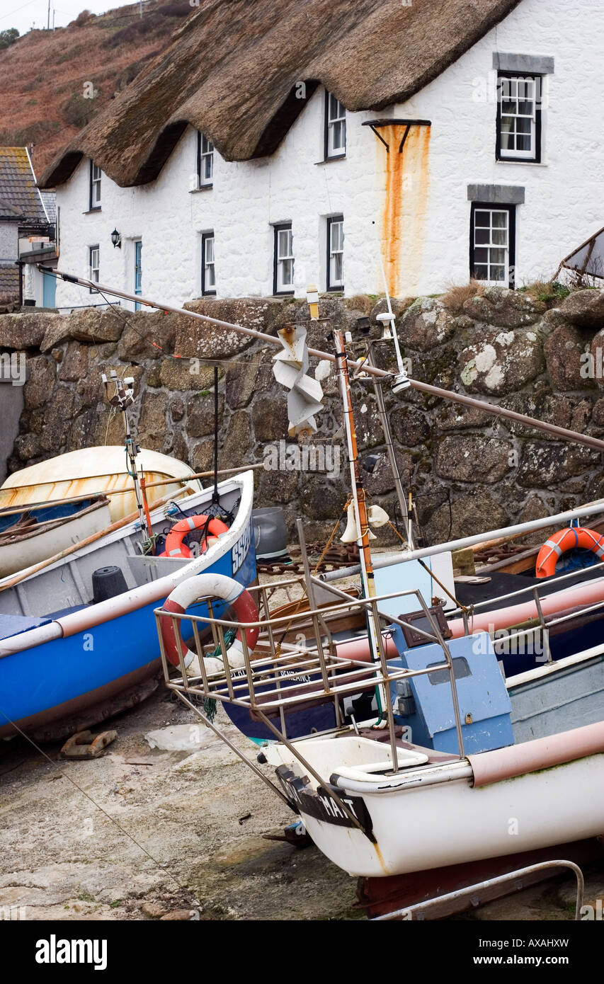 Fishing boats on the slip and a thatched white walled cottage at Sennen harbour, West Cornwall. Stock Photo