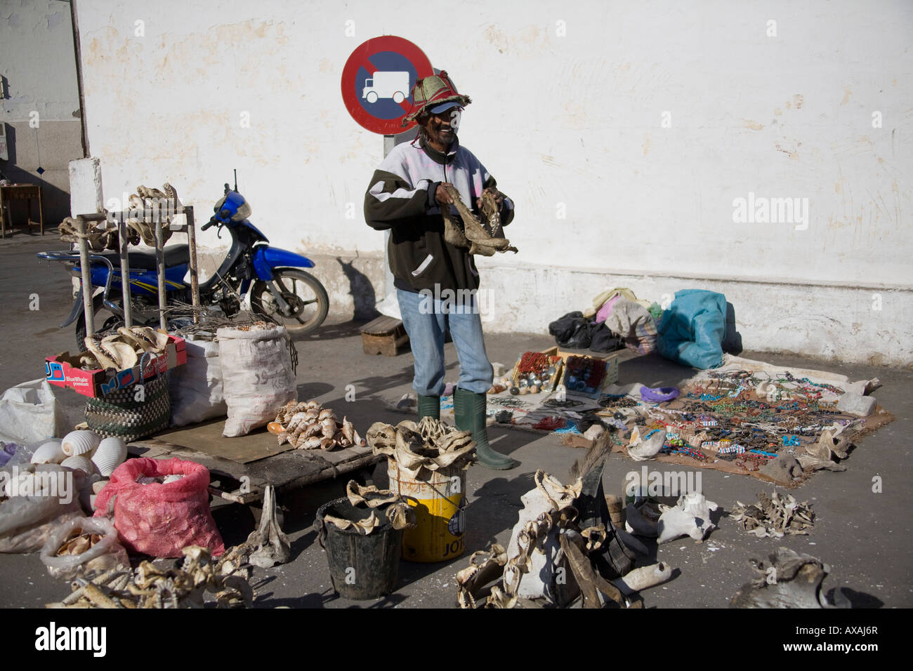 Street seller man selling shark's jaw in Agadir, Morocco. He wears a hat and hoodie Stock Photo