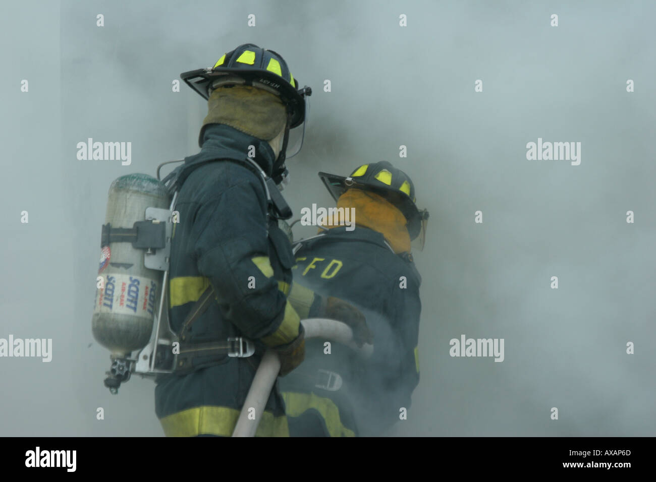 Fire fighters putting out fire in container Stock Photo