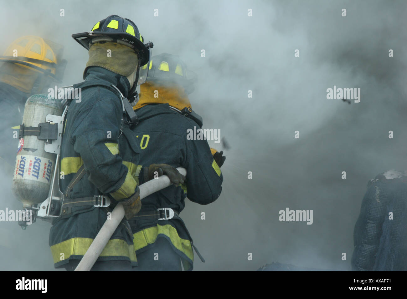 Fire fighters putting out fire in container Stock Photo