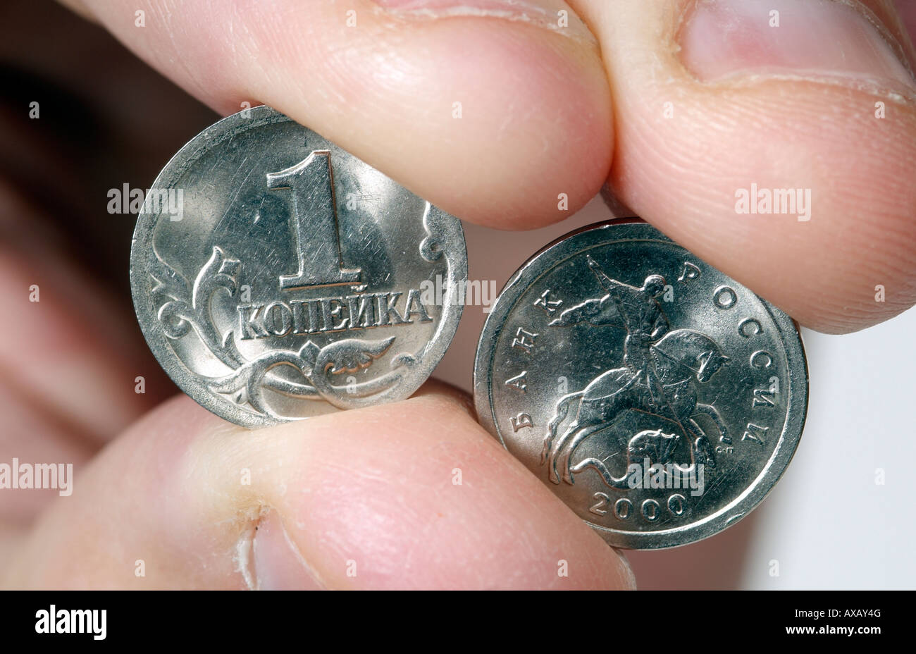 Russian Kopeck Coin being held between the thumb and finger a very low value coin Face and Rear of the coin Stock Photo