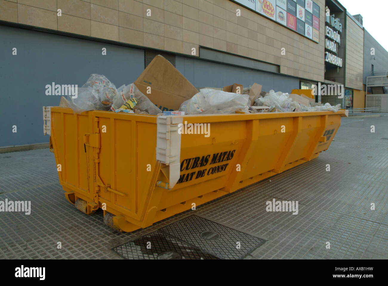A skip full of rubbish outside train station in Malaga Spain Stock Photo