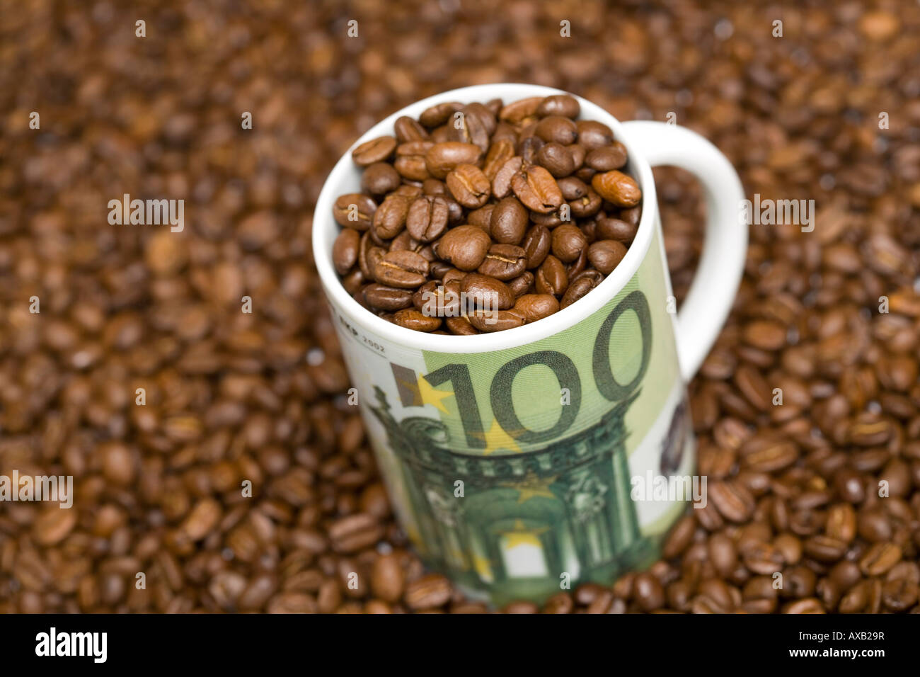 roasted coffee beans in a mug with 100 Euro sign Symbol coffee prices commodities agricultural commodities Stock Photo