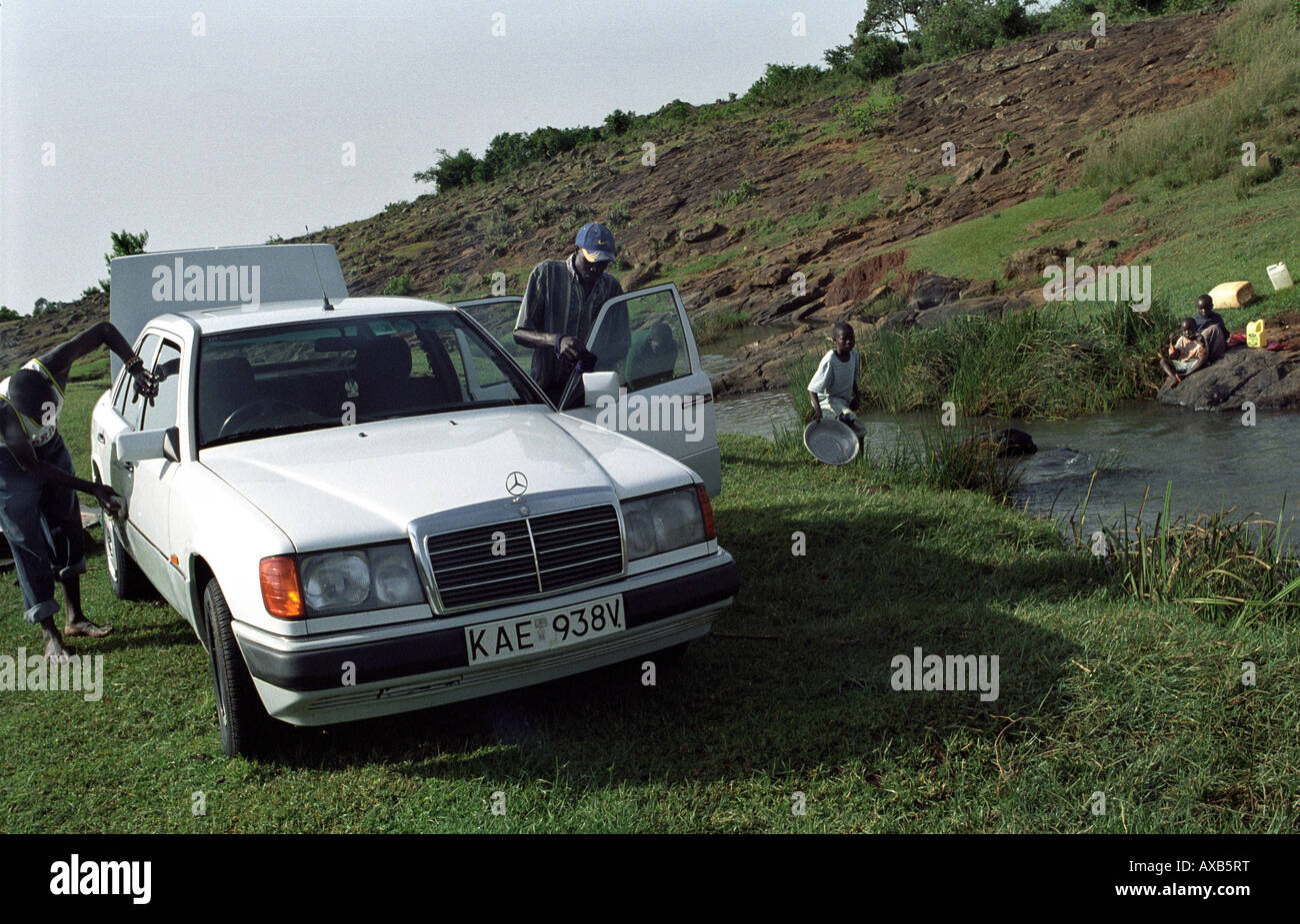 A group of Kenyans are washing their car, using the water from a river