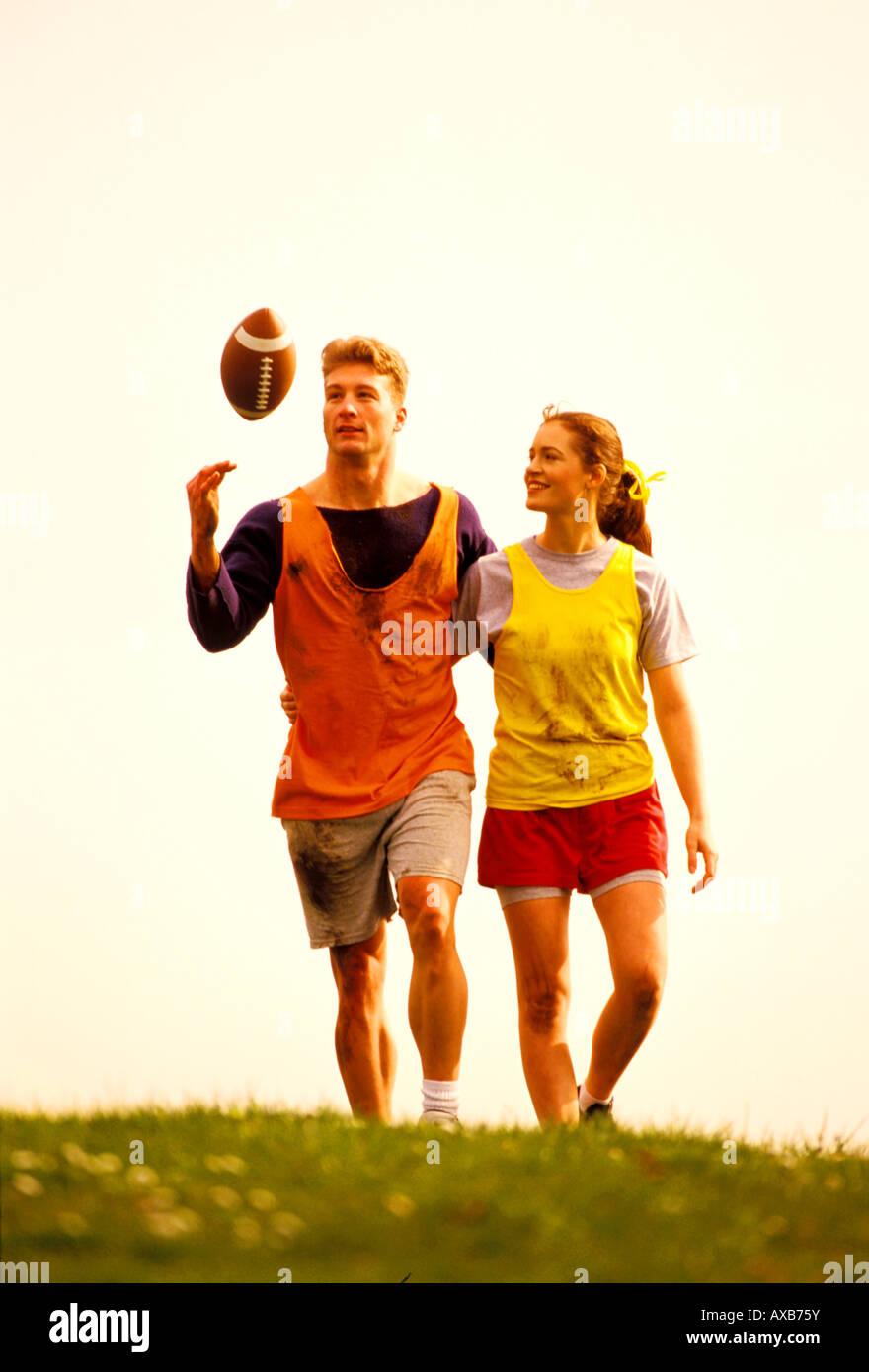 A young couple of collegians leave the field after a game of touch football Stock Photo