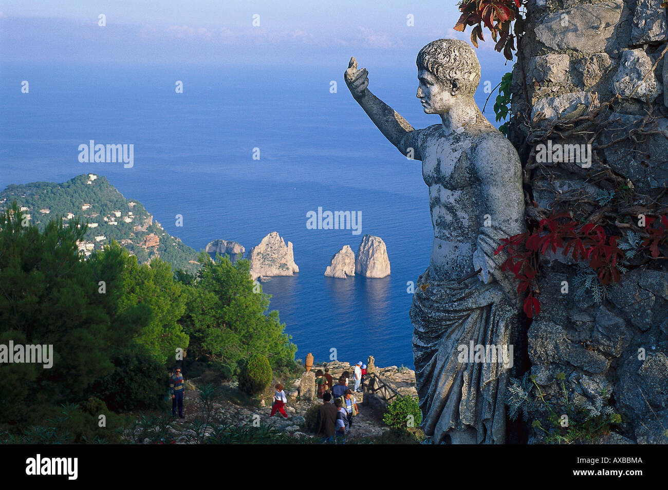 Weathered stone figure and group of tourists at the coast, Monte Solaro, Faraglioni, Capri, Italy, Europe Stock Photo