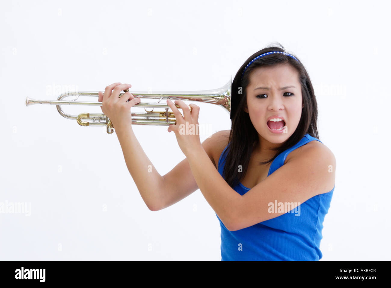 Stock Photograph of a Asian teen with a trumpet to her ear Stock Photo