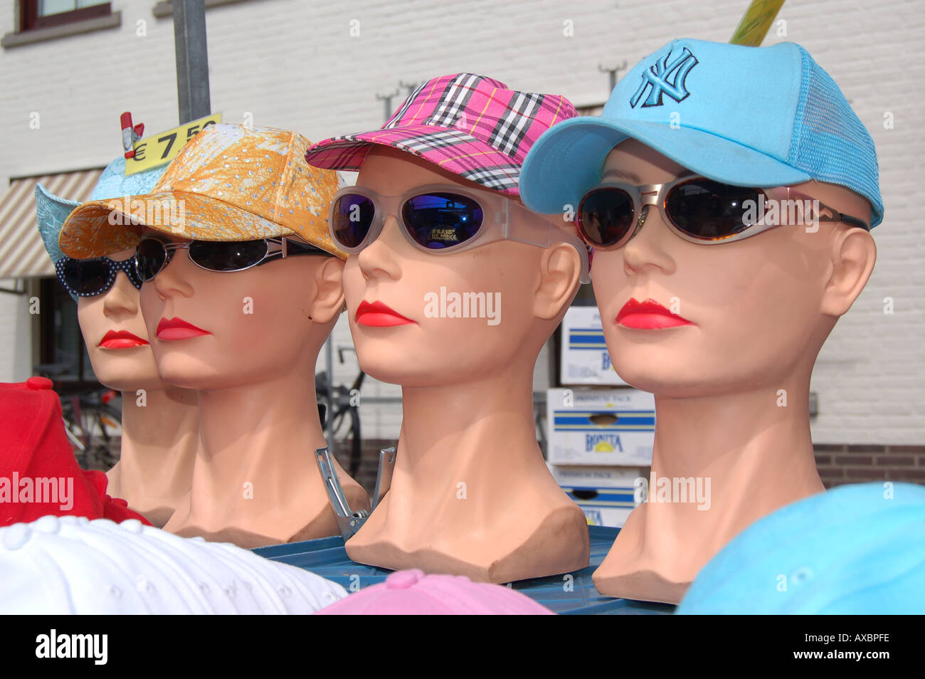 three mannequin heads wearing baseball caps and sunglasses Stock Photo