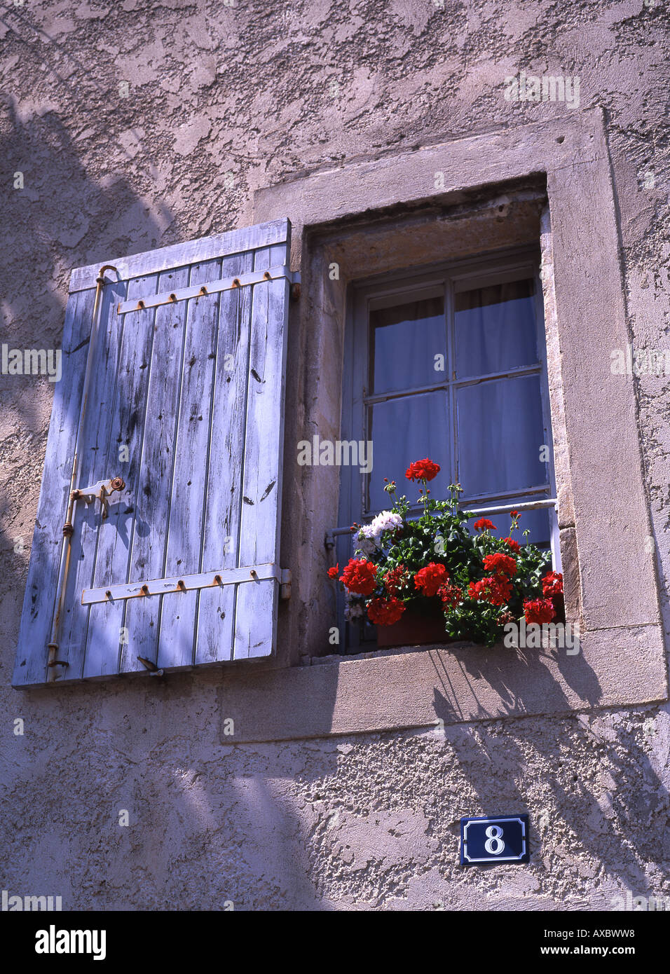 Traditional house with window shutters, balcony and flower baskets St Rémy de Provence France Stock Photo
