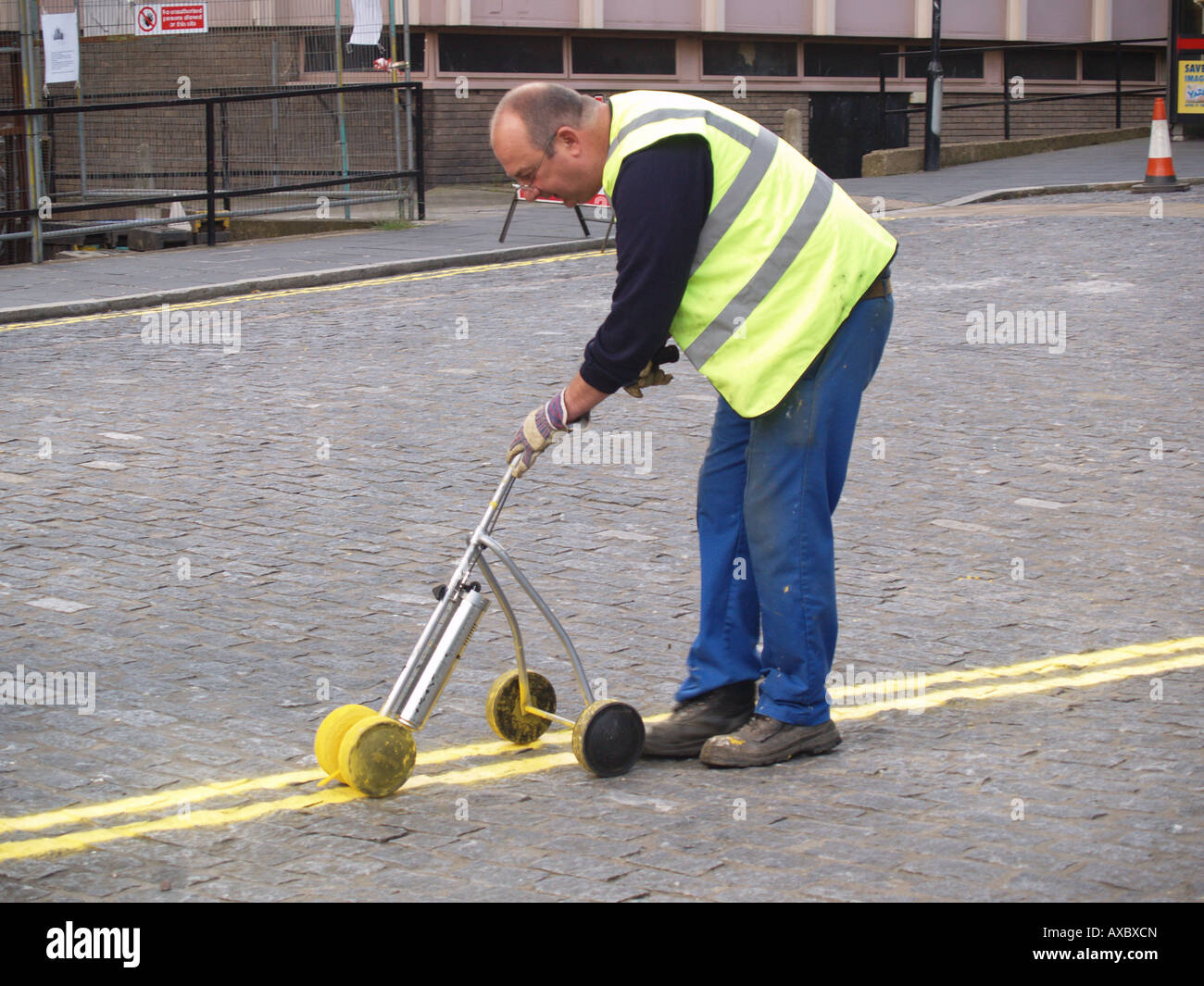 workman man painting yellow lines no parking road east midlands england
