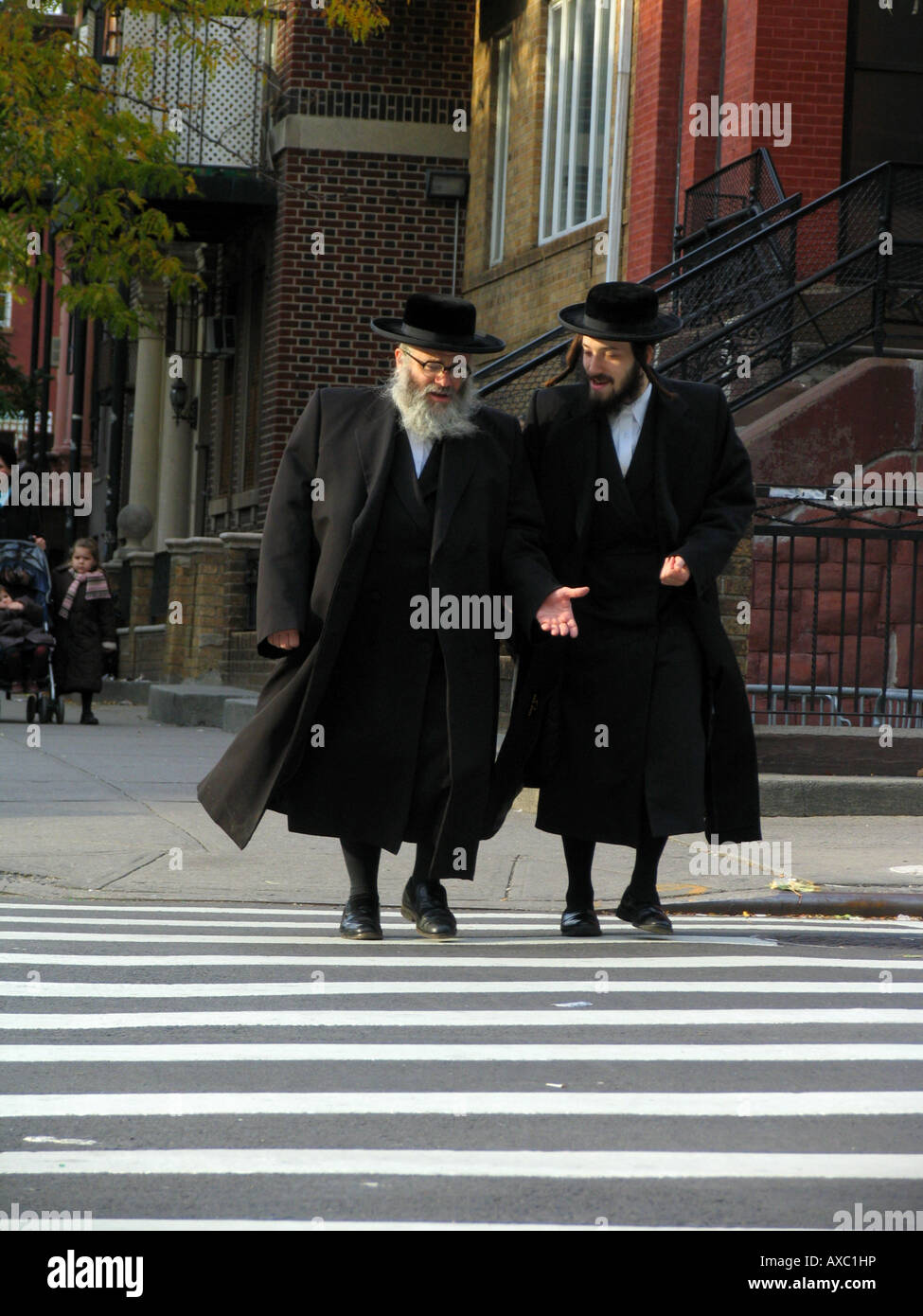 Jewish men in traditional clothes discussing while crossing a street, USA, Brooklyn, New York Stock Photo