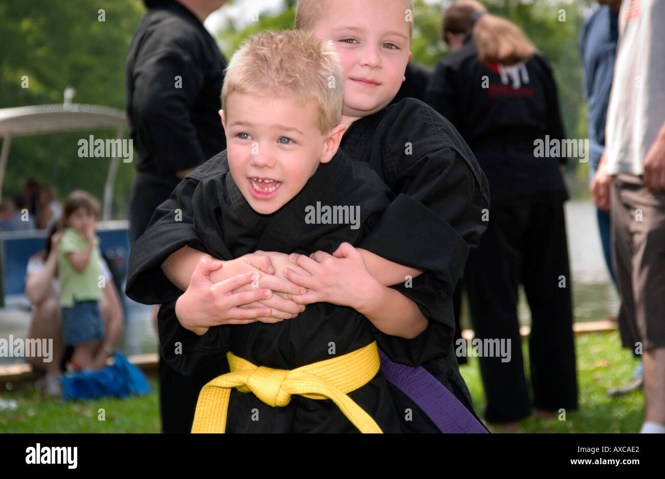 Kids dressed karate outfits play around at outdoor event Stock Photo