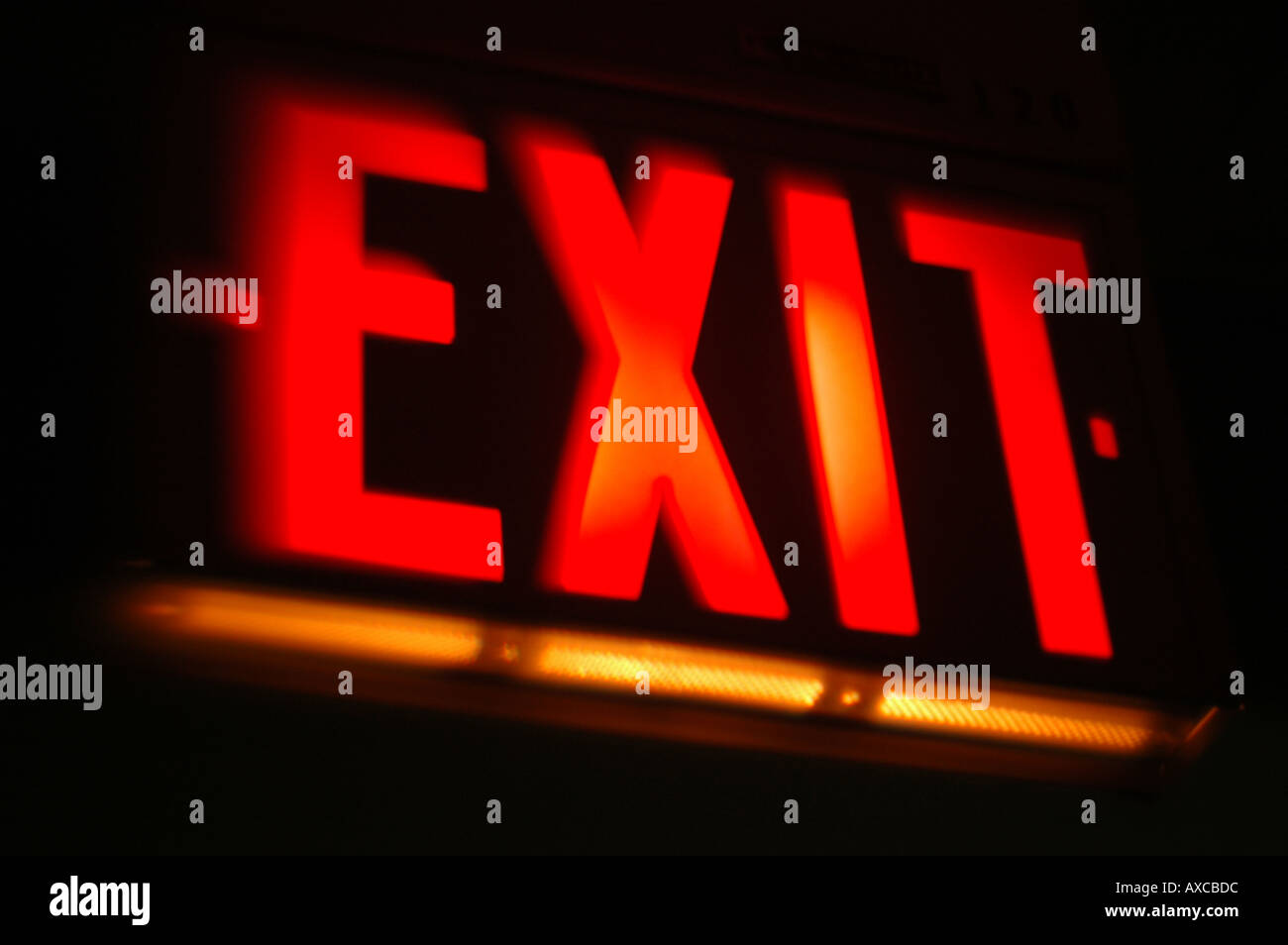 red Exit sign with dark building interior Stock Photo