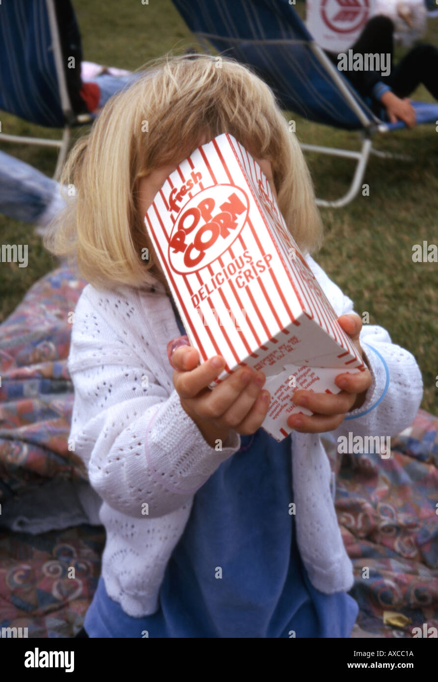 Young girl eating popcorn at a festival Stock Photo