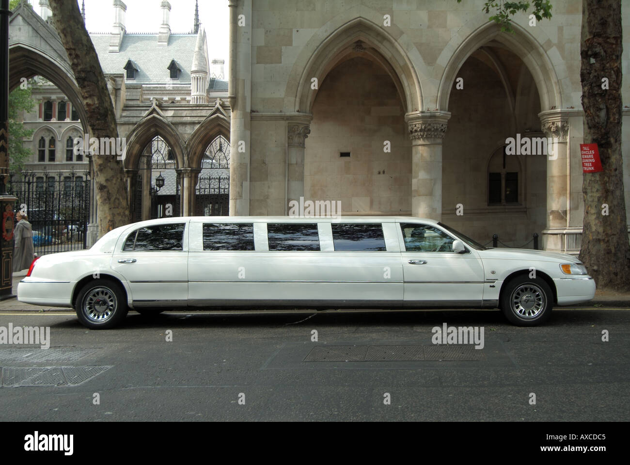 London white stretch limousine chauffeur driven luxury car parked in The Strand at the Law Courts for a special occasion Stock Photo