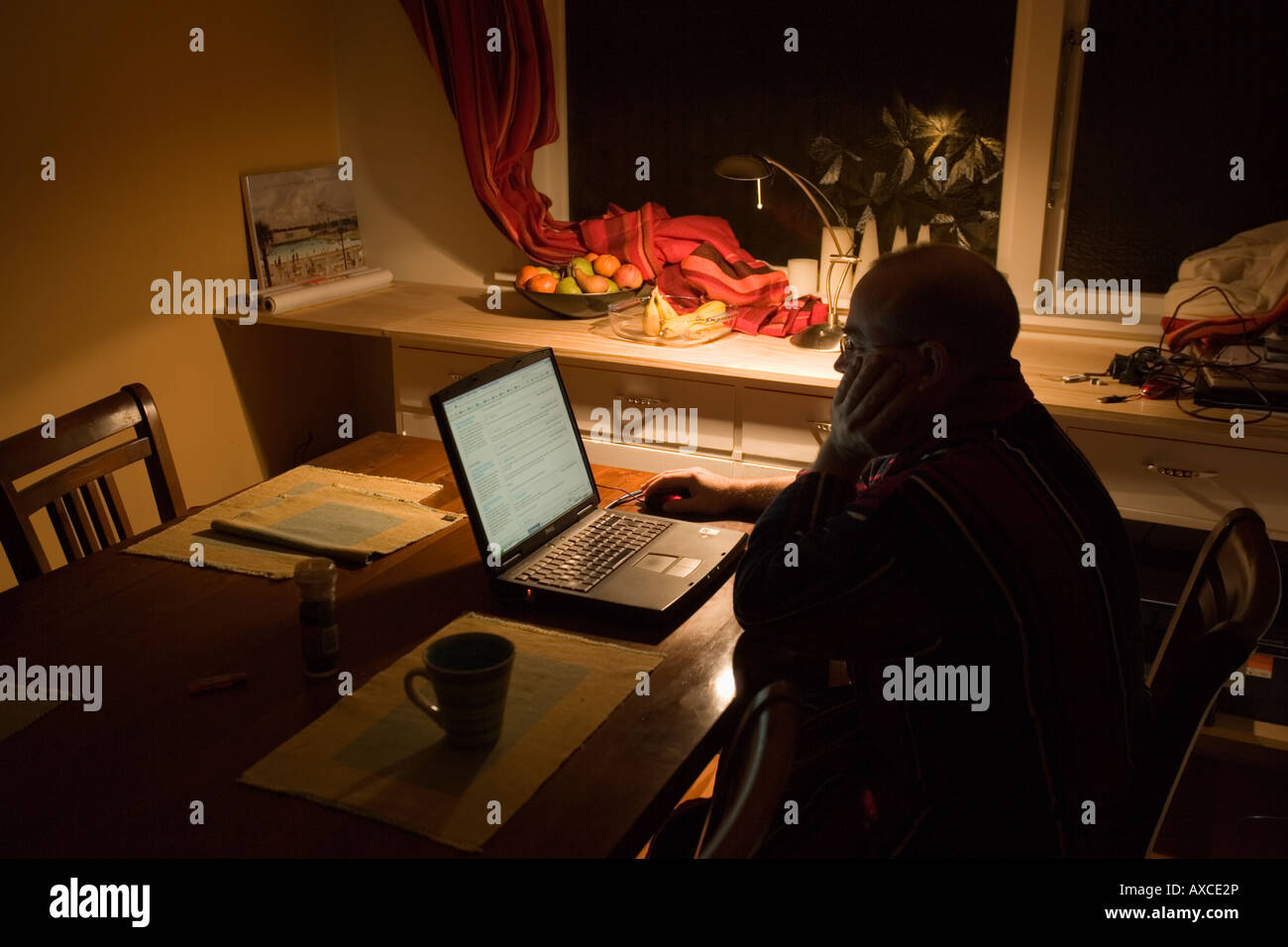 Man forties on the internet at home in a dark room Stock Photo