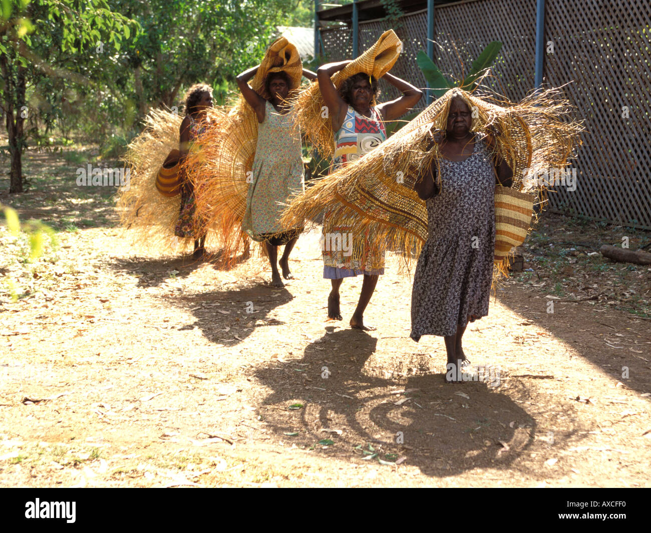 Aboriginal women bring their pandanus woven mats and baskets to Ramingining art centre to sell Arnhem land NT Australia Stock Photo