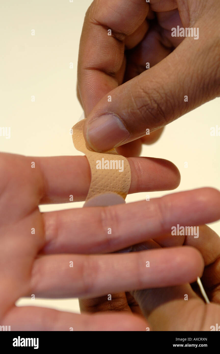 applying plaster to finger Stock Photo - Alamy