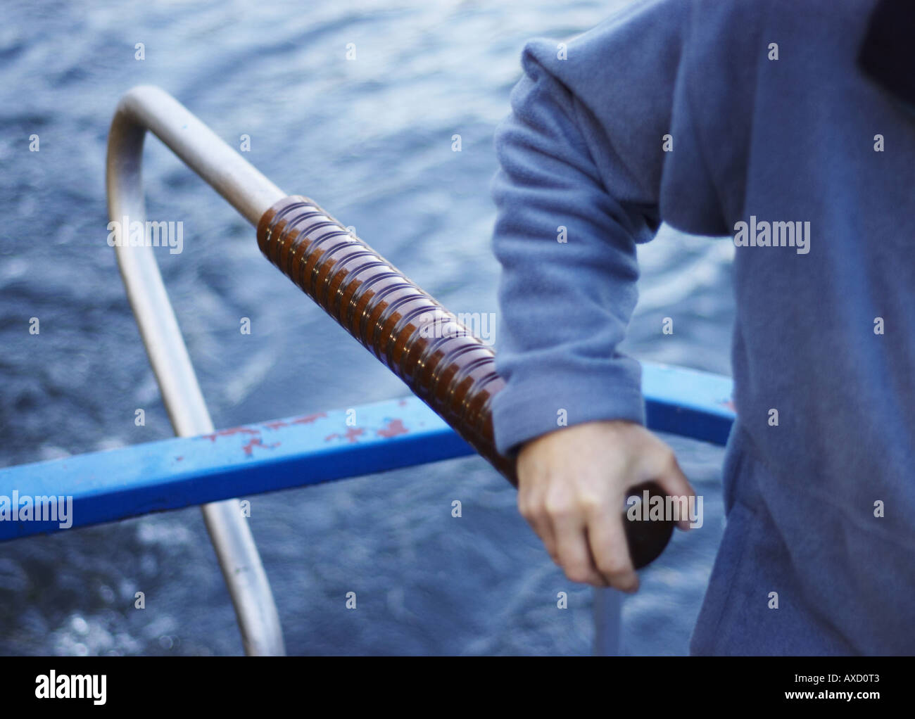 man steering canal boat with hand on the tiller Stock Photo