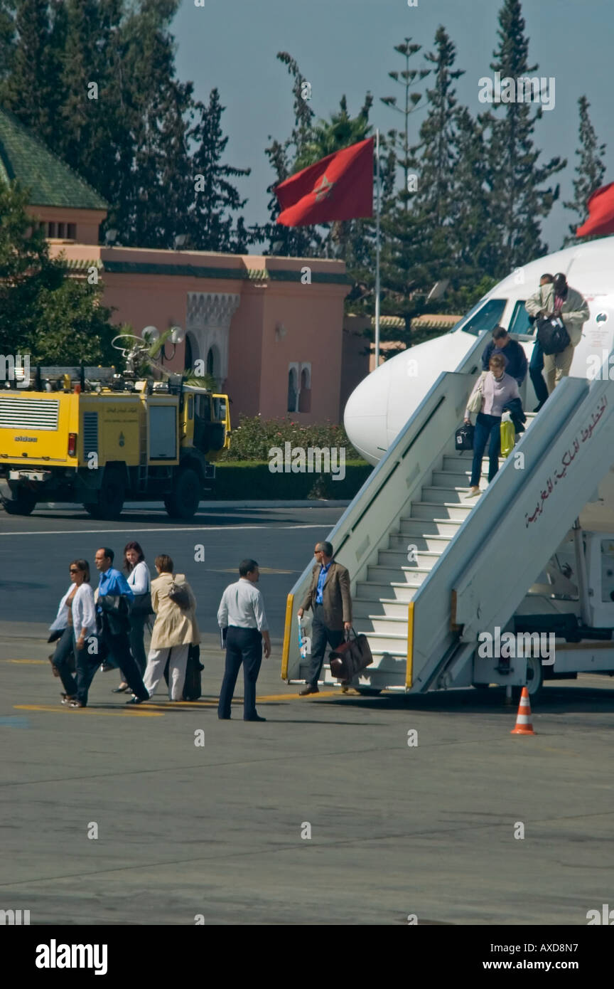 Vertical view of passengers disembarking an aeroplane down a flight of stairs onto the runway Stock Photo