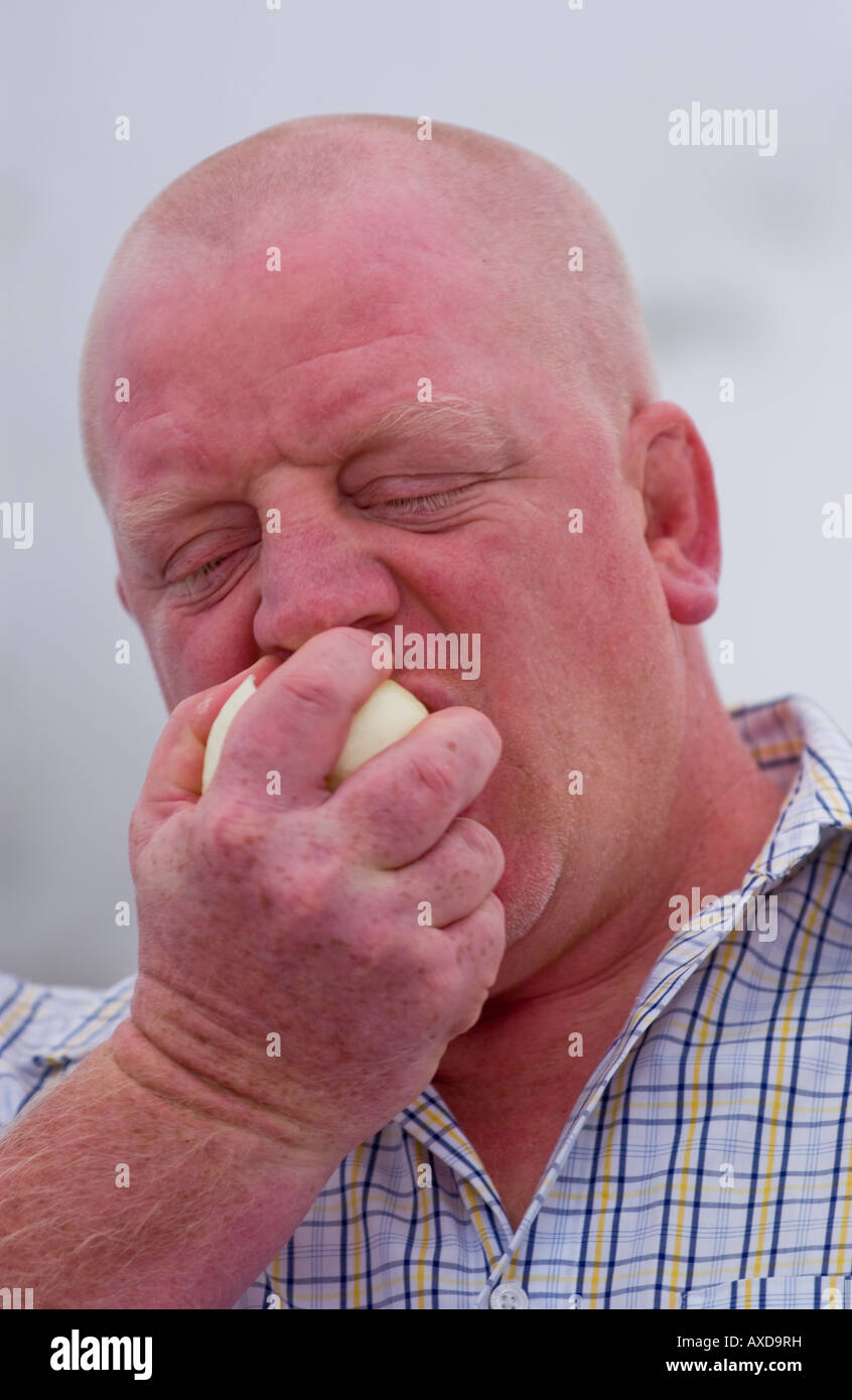 Man competing in onion eating competition during annual Newent Onion