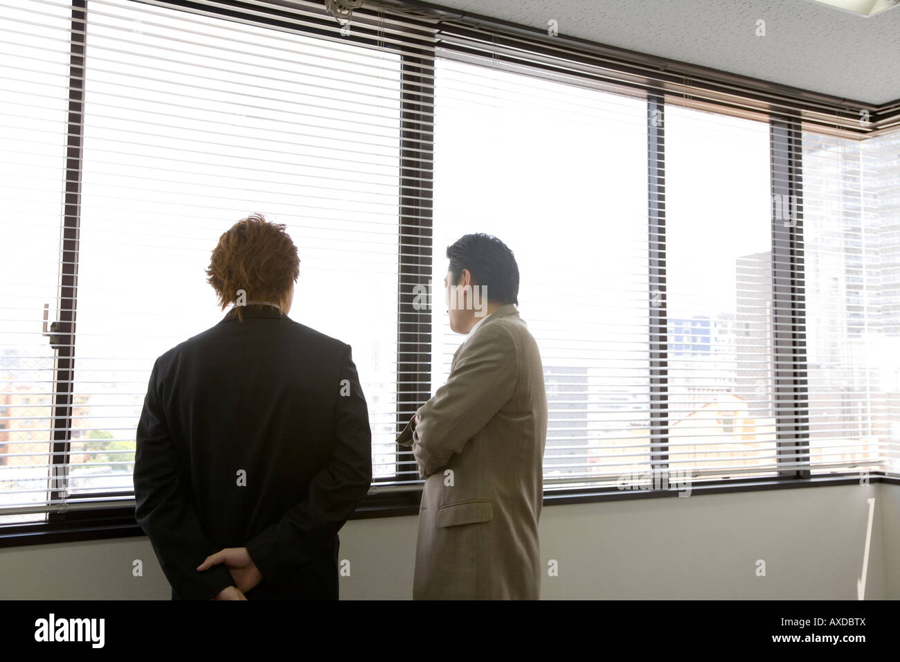 Two People Looking Through Blinds Stock Photo Alamy