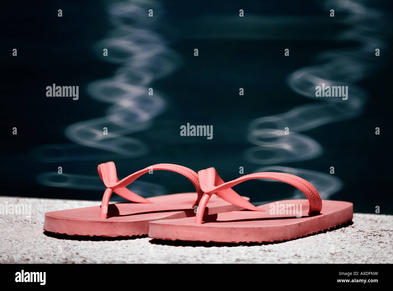 Closeup view of flip flops by the pool Stock Photo