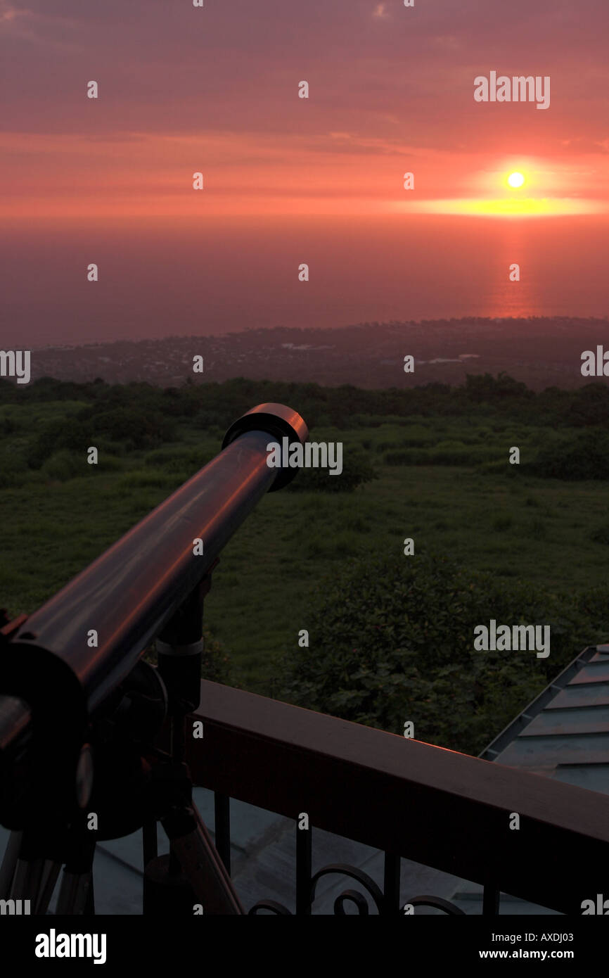 Shooting the Sun: A small telescope perched high above the Kailua Kona coast is aimed at the warm red glow of a setting sun Stock Photo