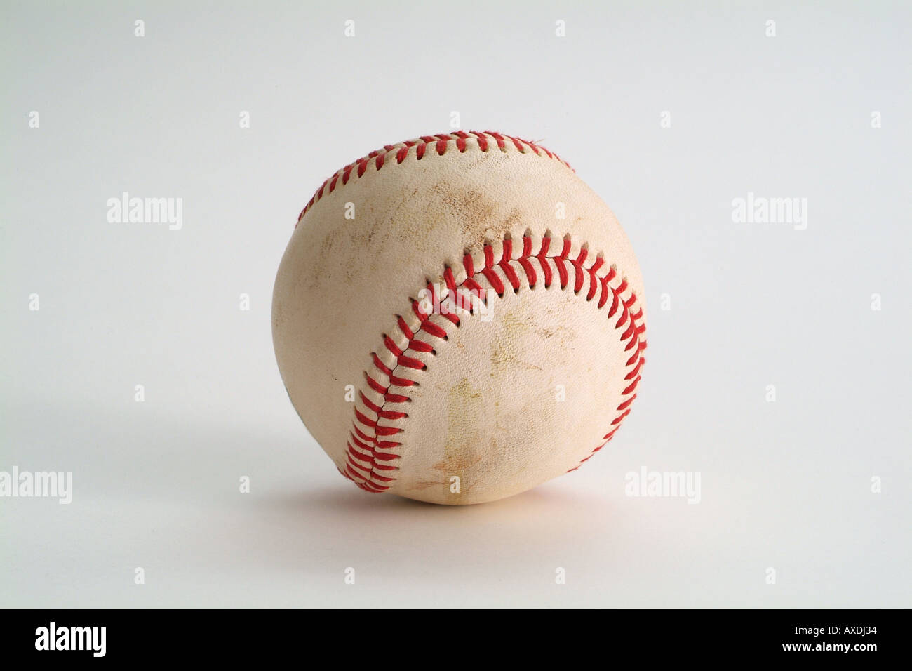 'Leather baseball' with red stitching slightly dirty as is used in American Baseball Games white background horizontal Stock Photo