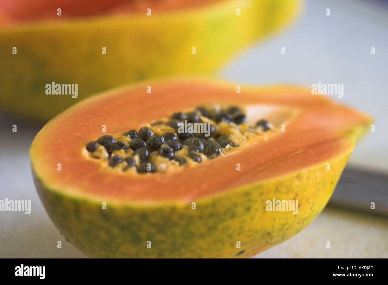 Papaya and Seeds: A freshly halved papaya full of round black seeds Stock Photo