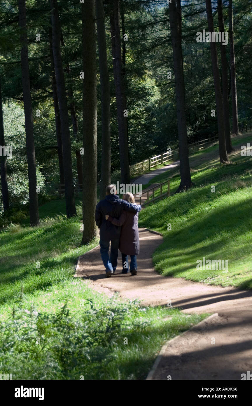 A young couple walking through the woods at the Derwent valley, Derbyshire Stock Photo