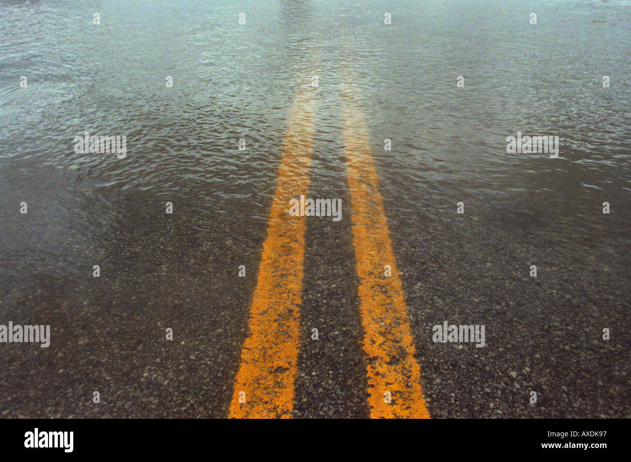 close-up of flooded road weather flood flooding midwest indiana yellow line road divided highway double Stock Photo