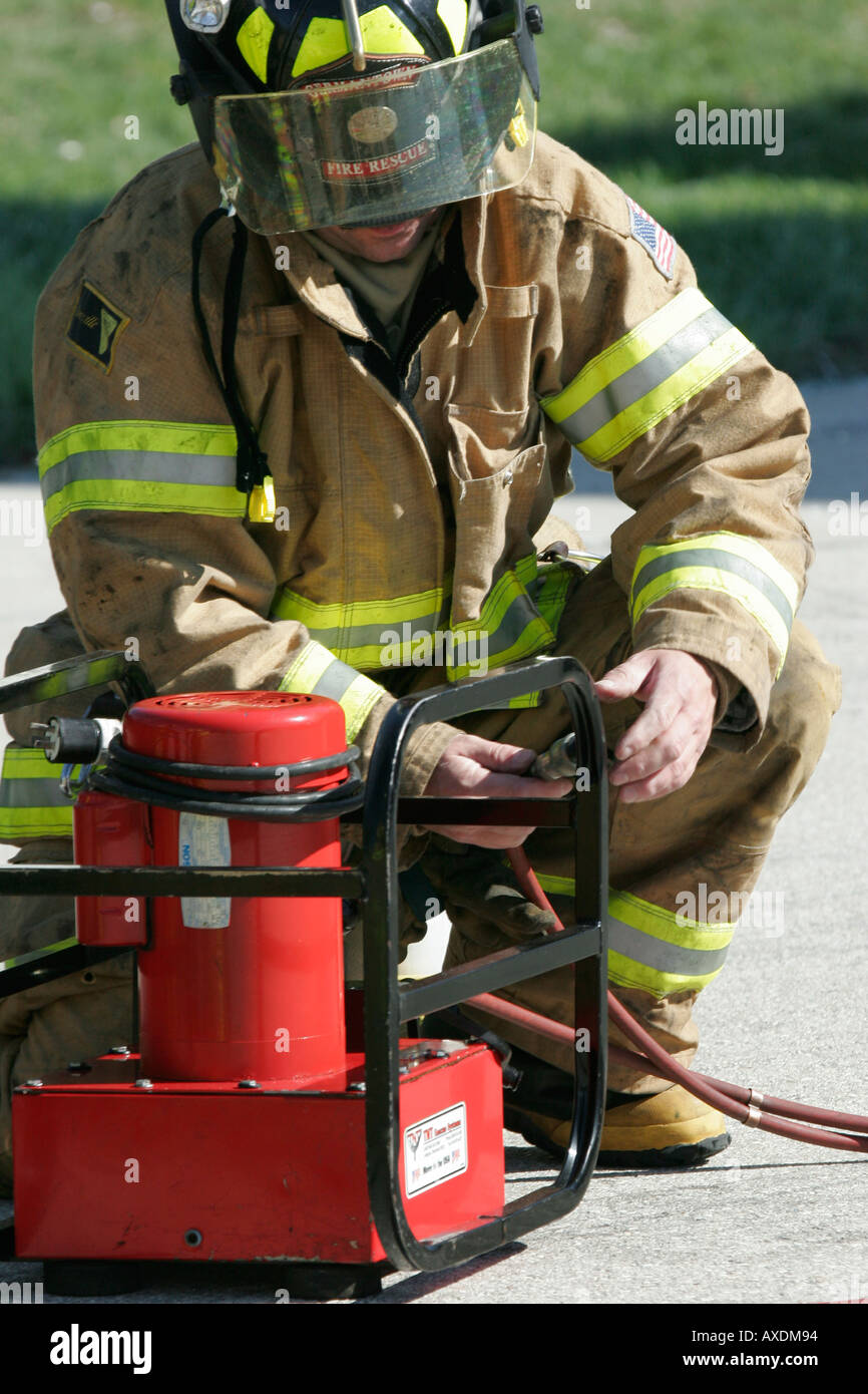 A fire fighter is starting up a red generator for the extrication ...