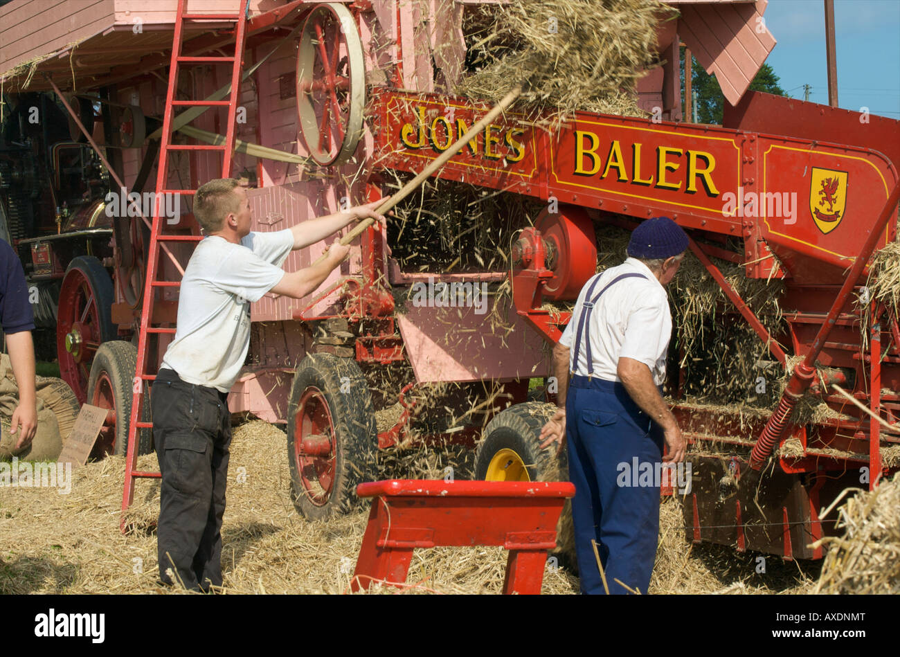 Men working with steam driven baling machine at Morval vintage steam rally Looe Cornwall Stock Photo