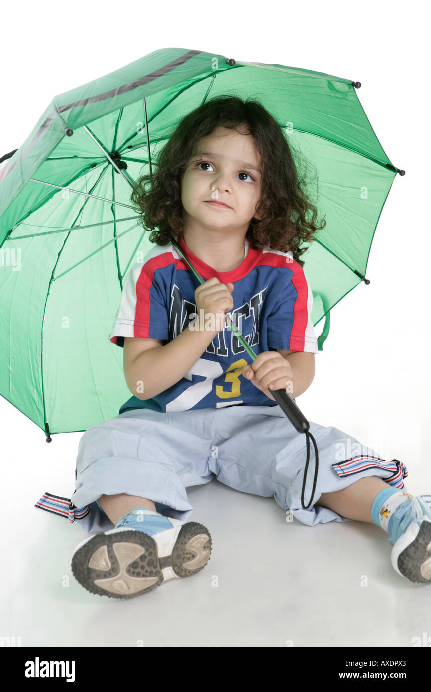 Boy sitting on floor and holding an umbrella Stock Photo Alamy