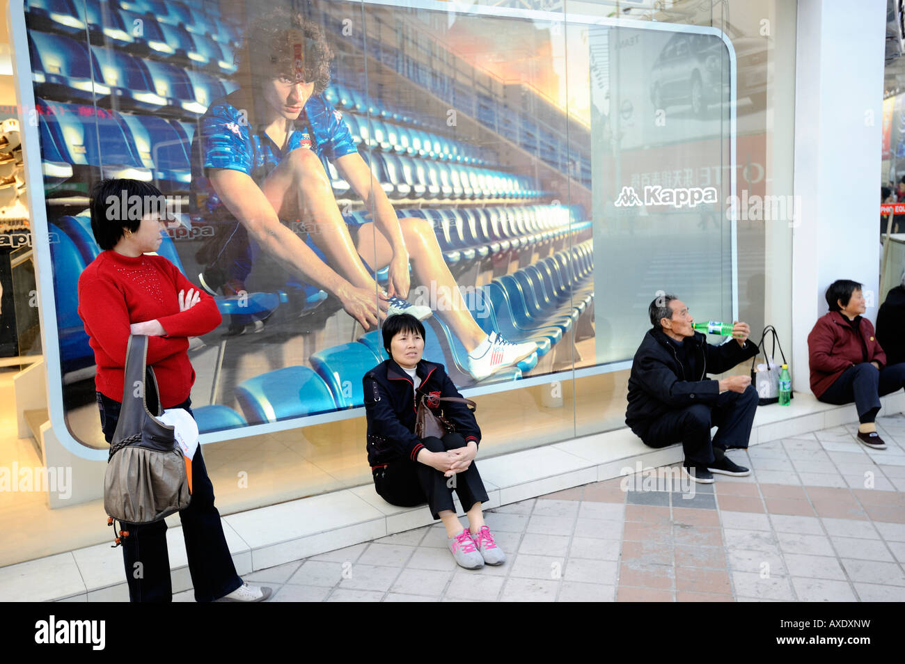 People rest themselves in front of a Kappa billboard in Wangfujing street  in Beijing, China. 23-Mar-2008 Stock Photo - Alamy
