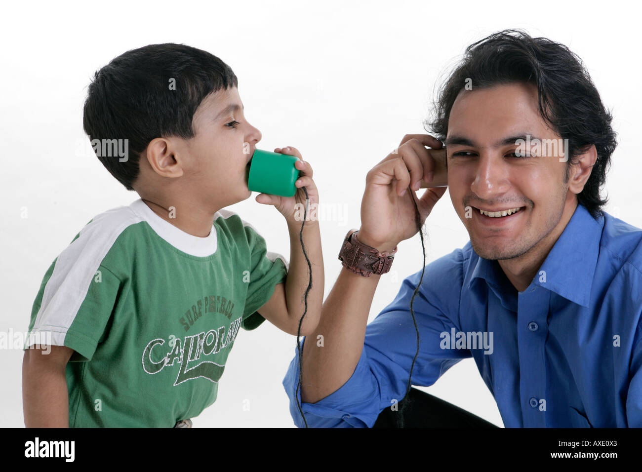 Father and son talking with a toy phone Stock Photo