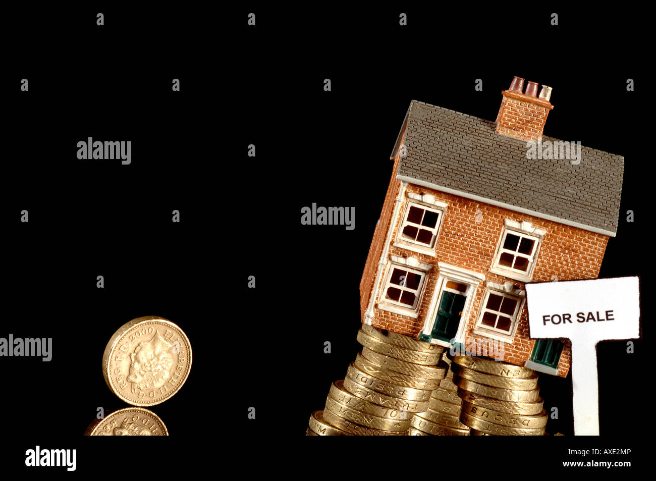 a falling house in for sale sunk in debt during the recession with british pound coins Stock Photo