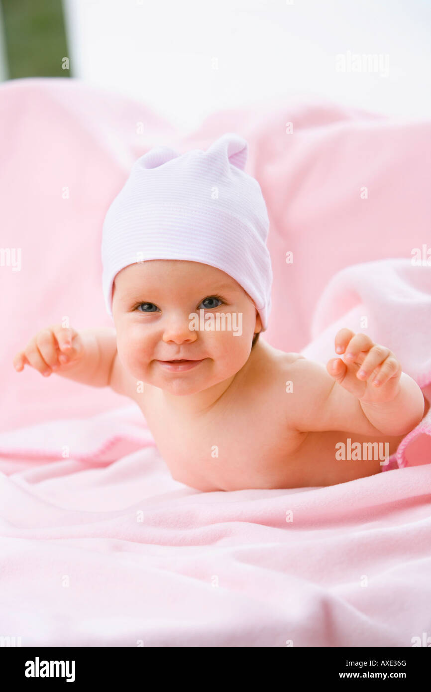 Baby girl (69 months) lying on belly, smiling Stock Photo Alamy