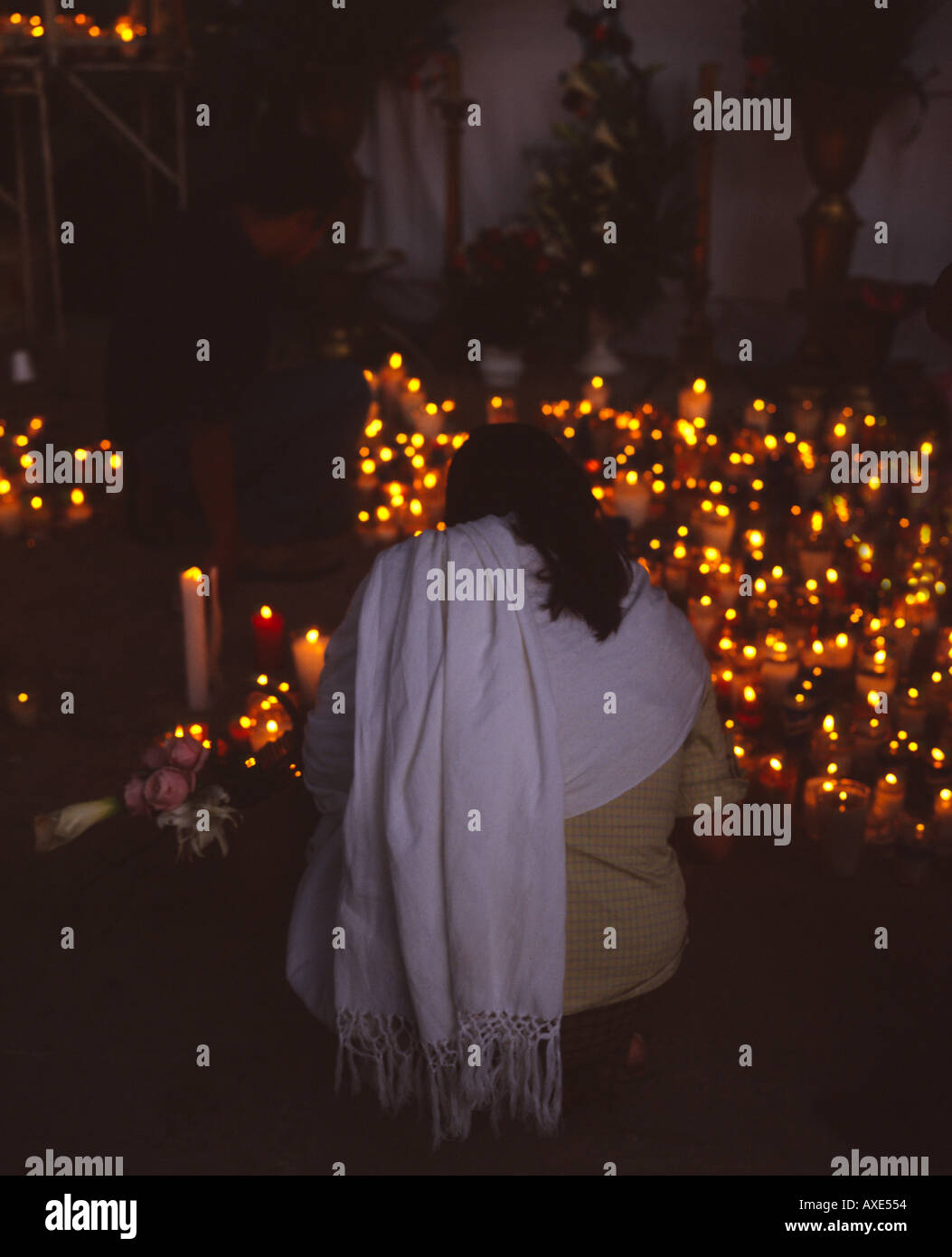 Woman lighting a candle at the fiesta de la Virgen de la Soledad Oaxaca