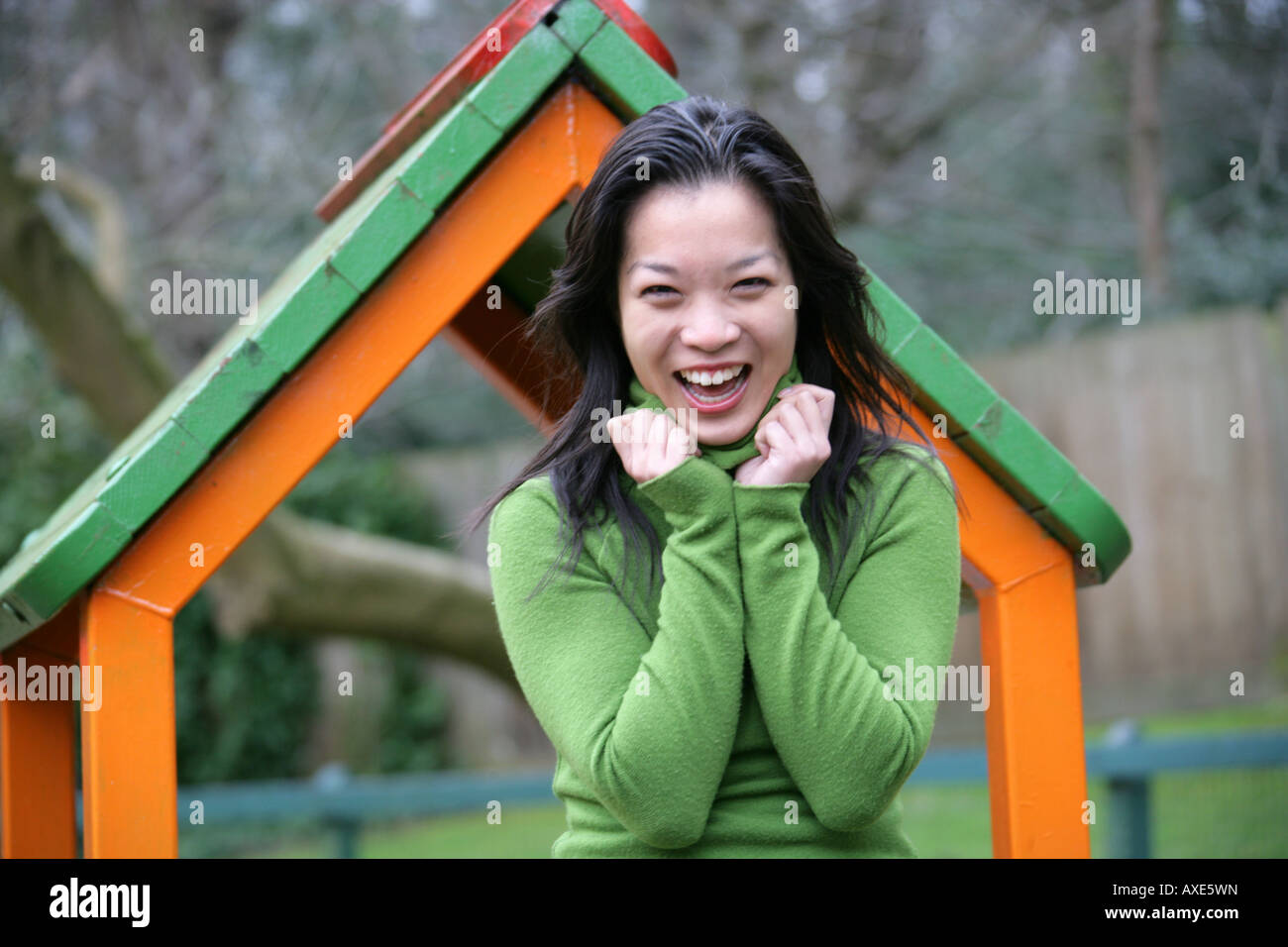 Portrait of a Young Chinese Woman in a Green Jumper in a Childrens Playground Stock Photo