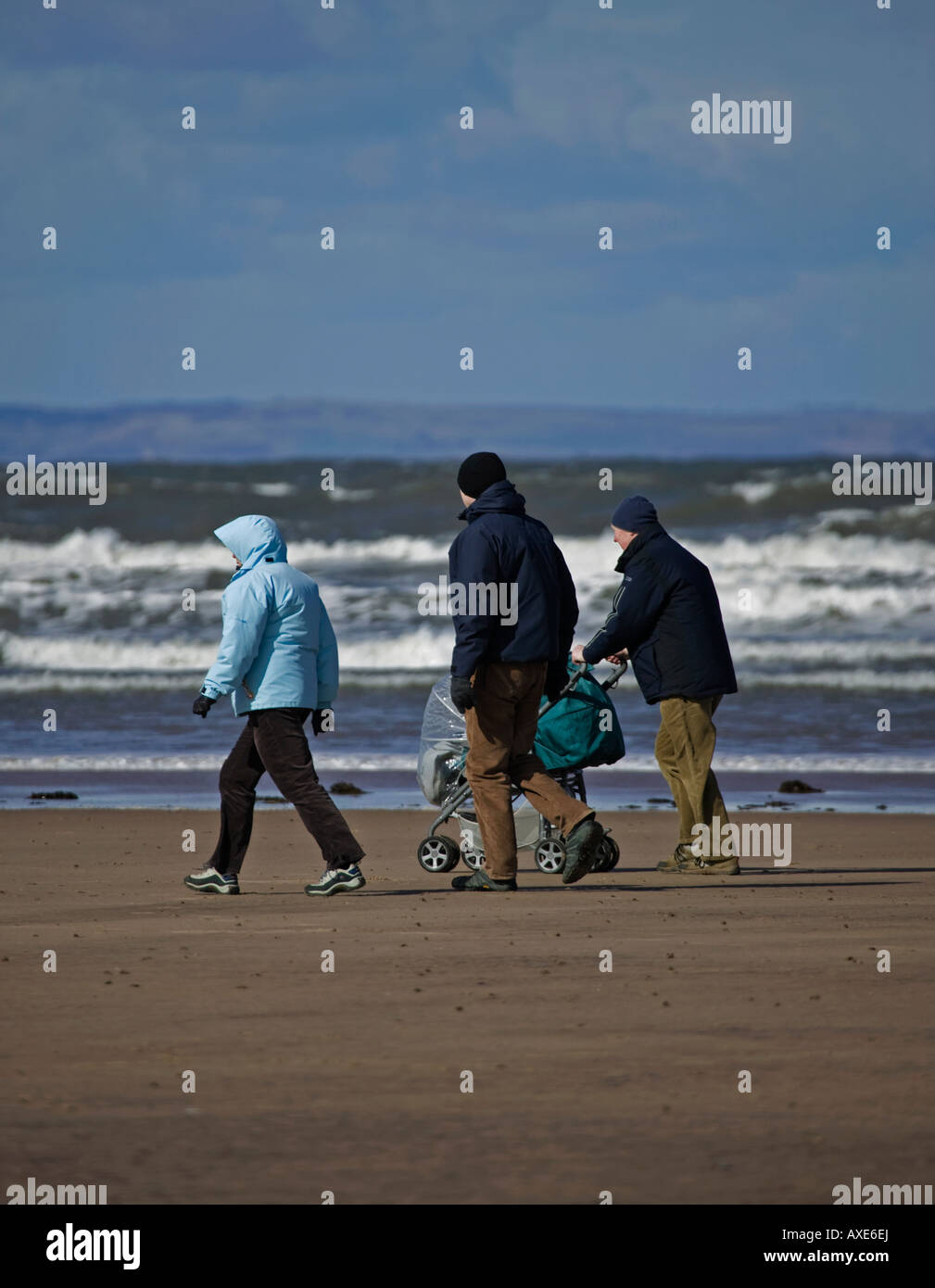 Family walking on beach with Bass Rock, Belhaven Bay, East Lothian, Scotland, UK, Europe Stock Photo