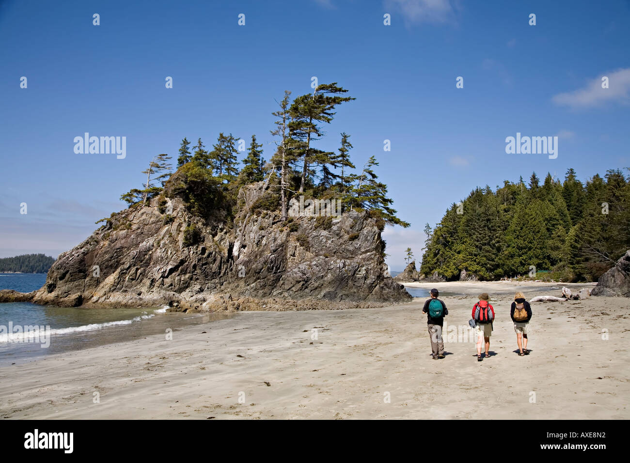 Three people walking on Brady beach Bamfirth west coast of Vancouver island Canada Stock Photo