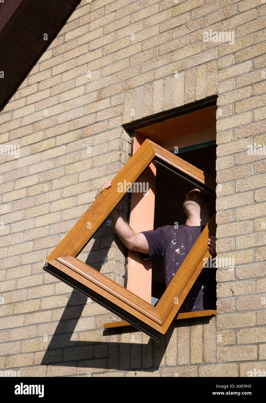 Man fitting replacement UPVC window Wales UK Stock Photo Alamy