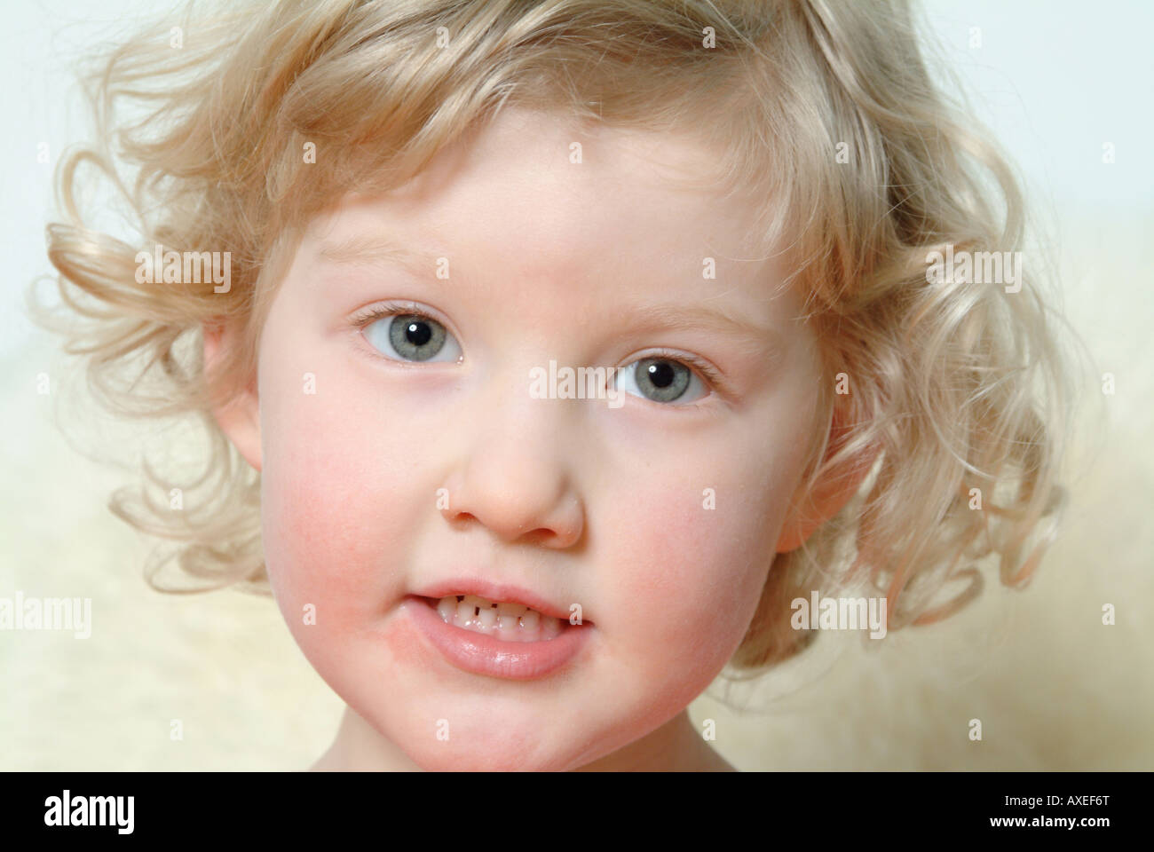 Little blond girl with blue eyes looking straight at camera, head